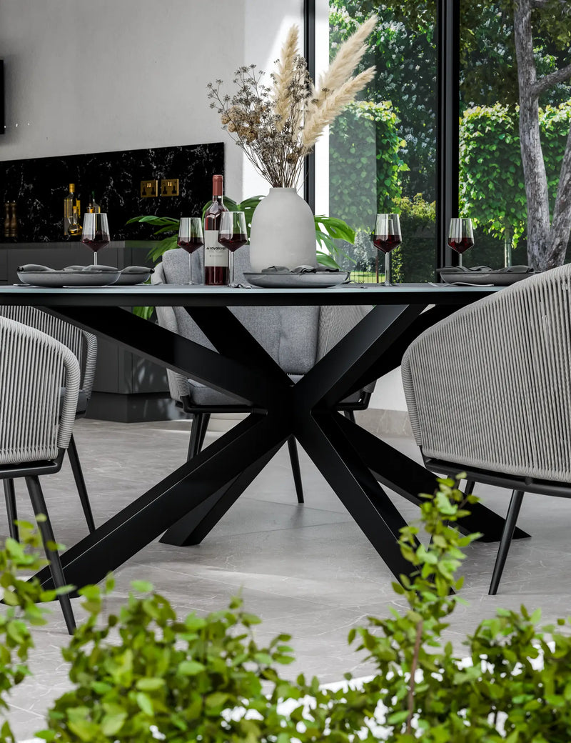 Aspen oval ceramic dining table and grey rope chairs arranged on a patio