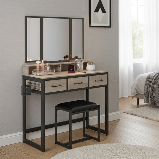 Dressing table with mirrors, drawers, and a stool in a bedroom setting.
