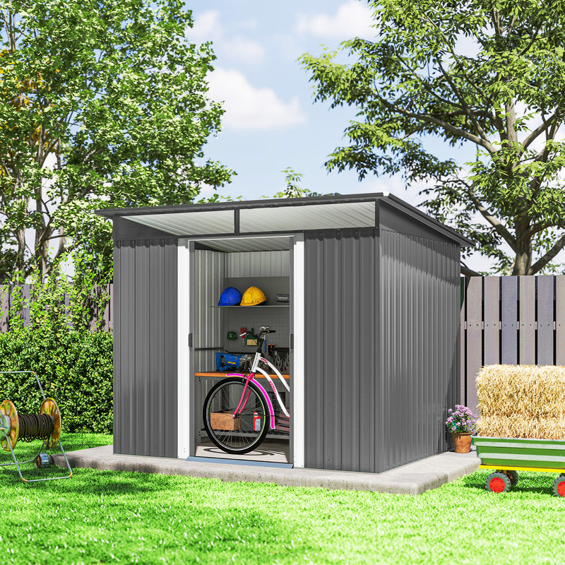Gray metal garden shed with a bicycle inside, surrounded by greenery.