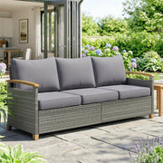 Gray outdoor sofa with cushions on a patio area with greenery and flowers.