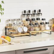 Black-framed bamboo racks holding glass spice jars on a kitchen worktop against white brick