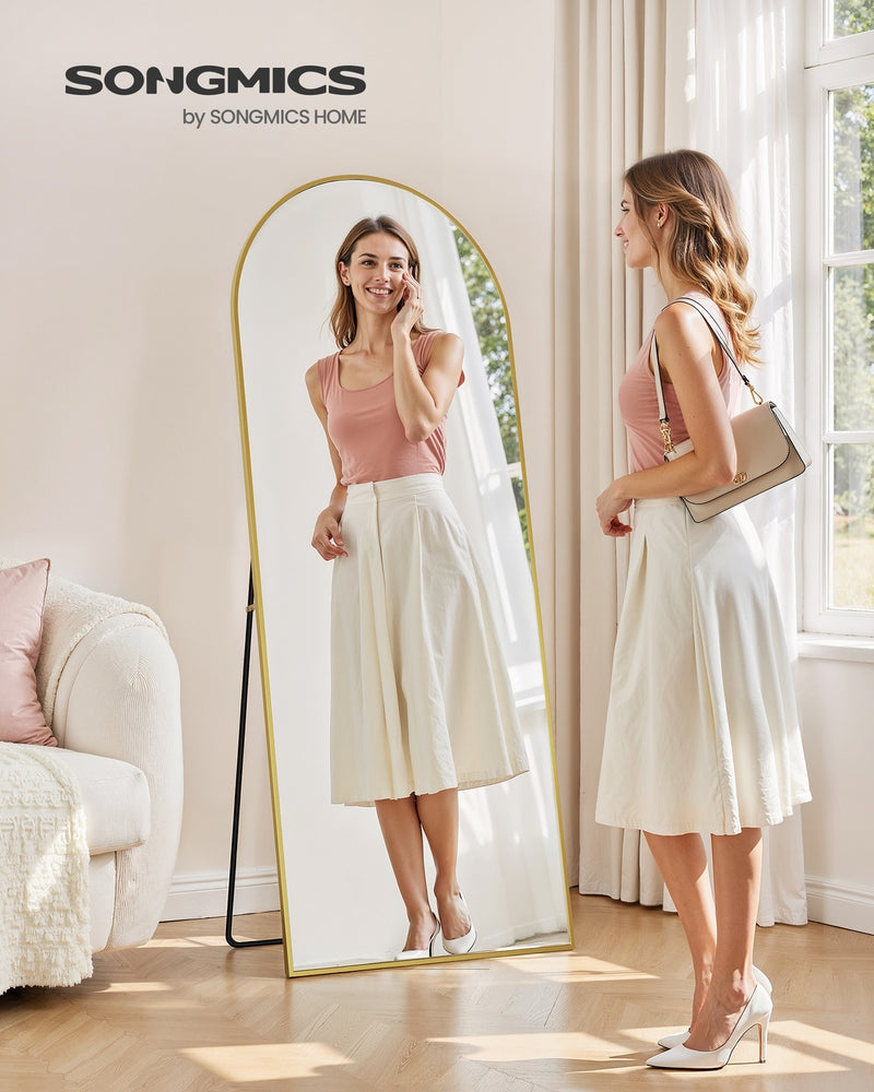Person checking their outfit in the arched full body mirror