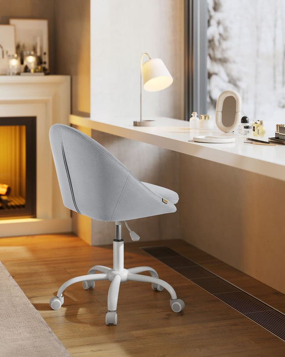 Image of a Modern Velvet Office Chair With Wheels. This is grey with white swivel wheels.