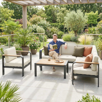 Man sitting on a patio with outdoor furniture and plants