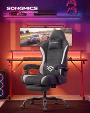 Dark Carbon Grey gaming chair reclined with footrest extended in a gaming desk setup