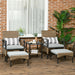 Image of a rattan patio furniture set consisting of 2 khaki coloured armchairs with grey seat cushions, 2 footstools and a coffee table with a shelf