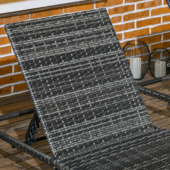 Image of a set of 2 grey rattan sun loungers with dark grey cushions and reclining backrests