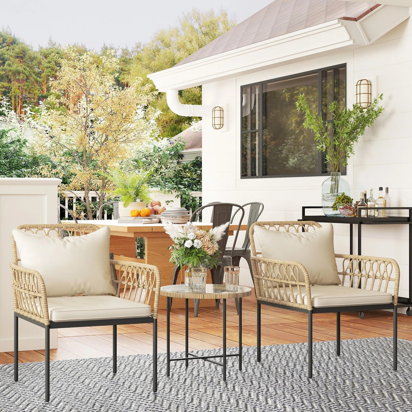 A picture of a 3 piece black rattan bistro set with white cushions 