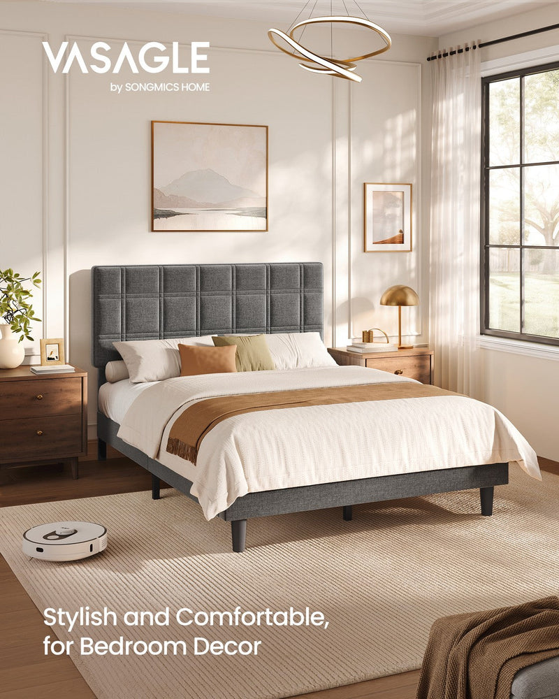 Vasagle upholstered double bed in a bright bedroom with a robot vacuum passing under the raised frame