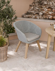 Sol rope dining chair with cushion beside the Roma bistro table