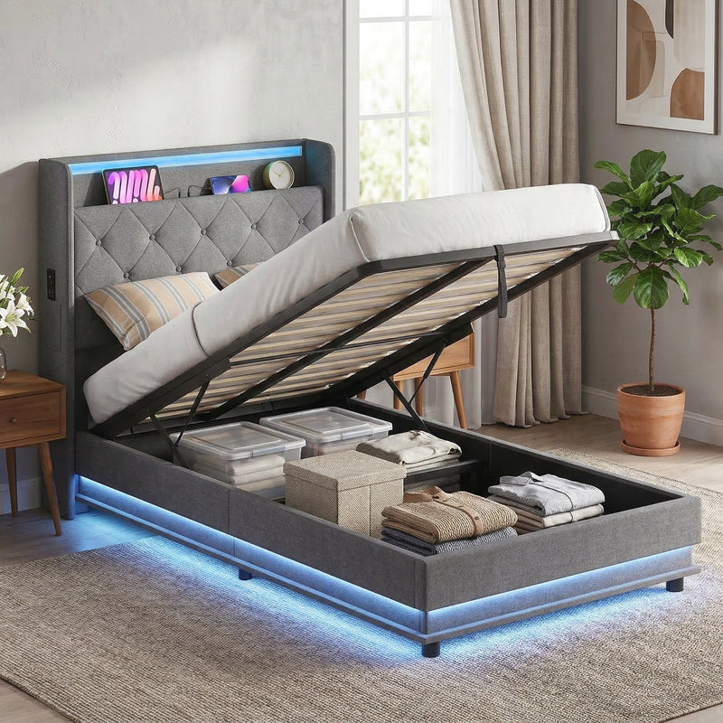 Single ottoman bed in a bedroom with the base raised over folded clothes and boxes