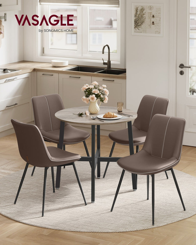 Heather Greige round dining table set with four brown chairs in a bright kitchen