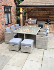 Royalcraft Wentworth rattan cube set with grey cushioned chairs around a glass-top dining table