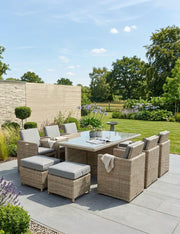 Royalcraft Wentworth 10 seater rattan cube dining set with grey cushions and a glass-top table on a patio