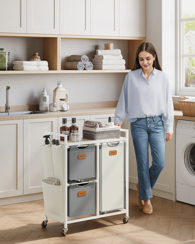 Woman pushing a laundry cart in a kitchen with cabinets and appliances.