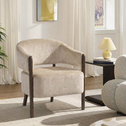 Beige accent chair styled in a living room beside a table lamp