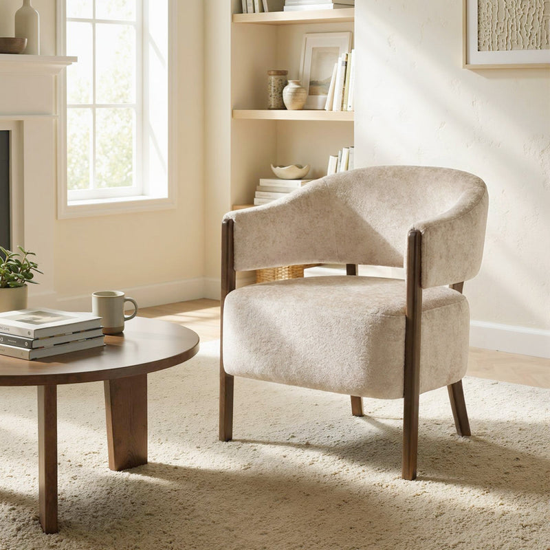 Beige accent chair next to a round coffee table in a living room