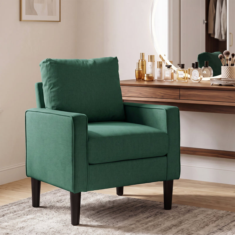 Dark green accent chair beside a dressing table in a bedroom
