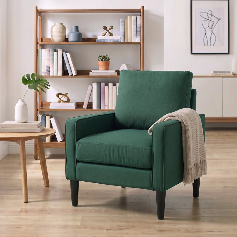 Dark green accent chair in a living room with a cream throw over one arm
