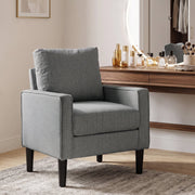 Dark grey accent chair beside a dressing table in a bedroom