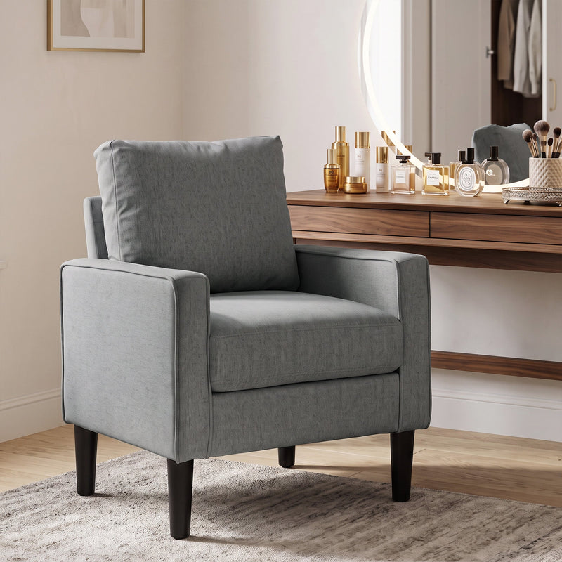 Dark grey accent chair beside a dressing table in a bedroom