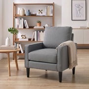 Dark grey accent chair in a living room with a cream throw over one arm