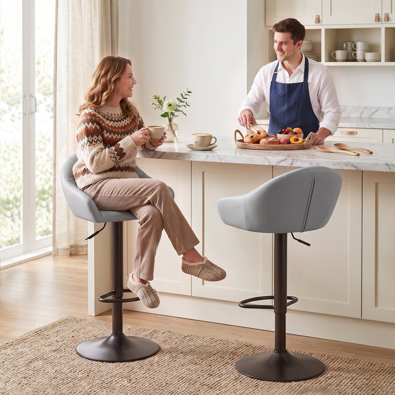 Couple seated on two grey bar stools at a cream kitchen island with coffee and pastries