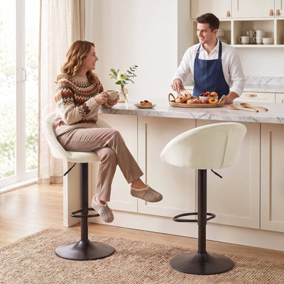 Woman sitting on a cream white Homcom bar stool at a marble kitchen island