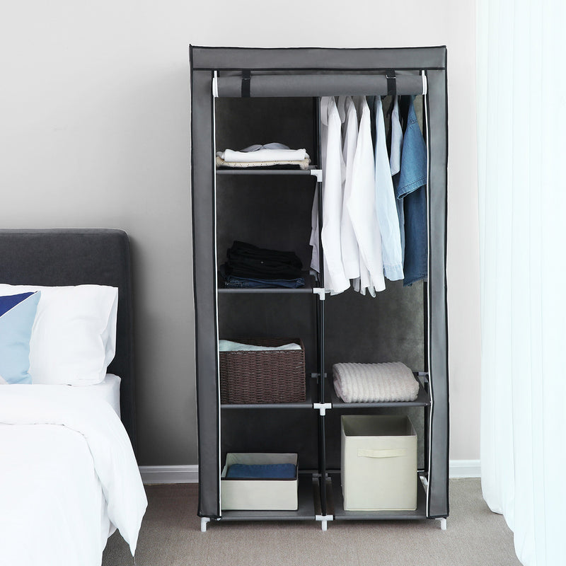 Grey canvas wardrobe with cover on in a bedroom beside a bed