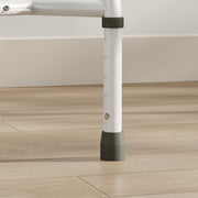 Close-up of an adjustable commode chair leg with height holes and grey rubber foot