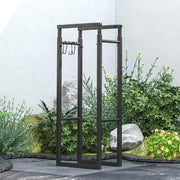 Log holder frame with hooks standing empty in a garden setting with rocks and plants