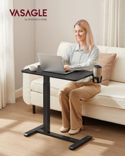 Seated user typing on a laptop at the table beside a sofa