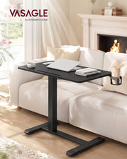 Overbed table set across a sofa in a living room with a fireplace