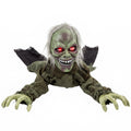 Animated crawling zombie Halloween decoration with grey-green skin and glowing red eyes