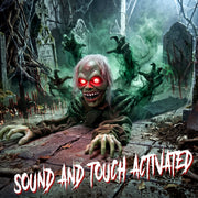 Crawling zombie decoration reaching out with clawed hands among gravestones