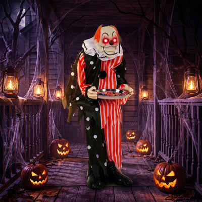 Animated candy tray clown decoration on a haunted porch with jack-o'-lanterns and lanterns