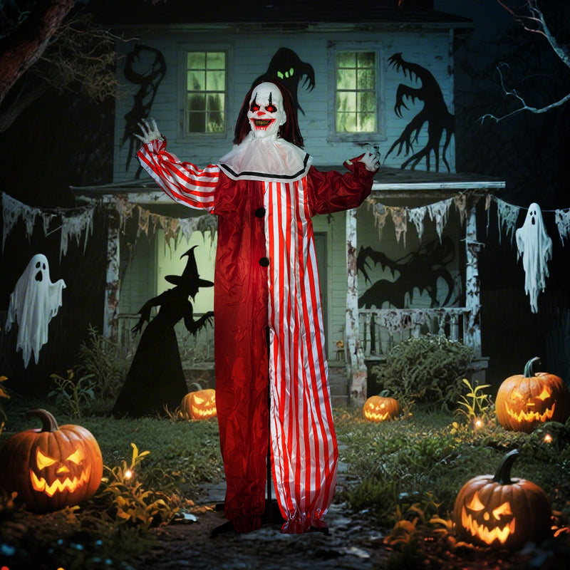 Animated Halloween clown decoration displayed in a haunted house yard scene with jack-o-lanterns and ghosts