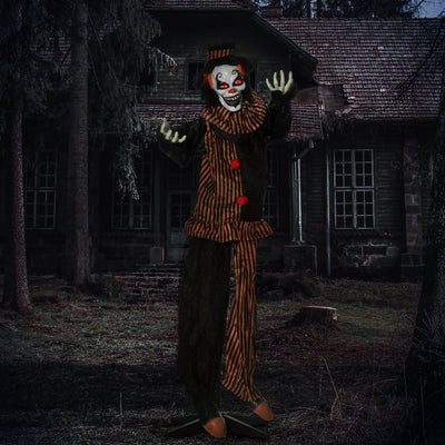 Striped clown decoration lit up at night outside a derelict house
