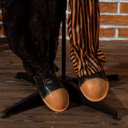 Close-up of the clown's shoes resting on its black cross-shaped base stand