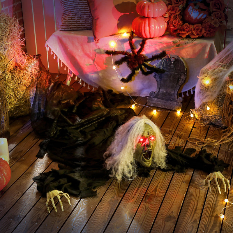 Outsunny Halloween crawling zombie decoration on a porch floor beside a decorative spider and gravestone