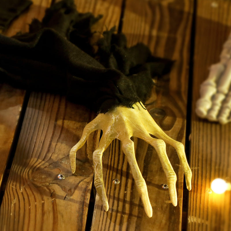 Close-up of the zombie decoration's clawed hand detail on a wooden porch floor