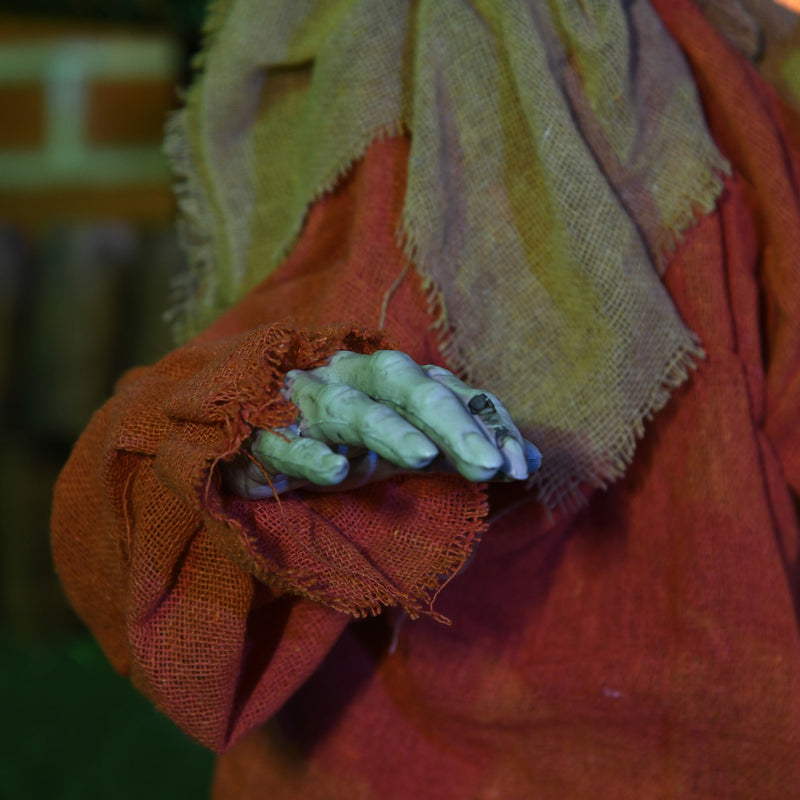 Close-up of the figure's grey skeletal hand against its orange fabric sleeve