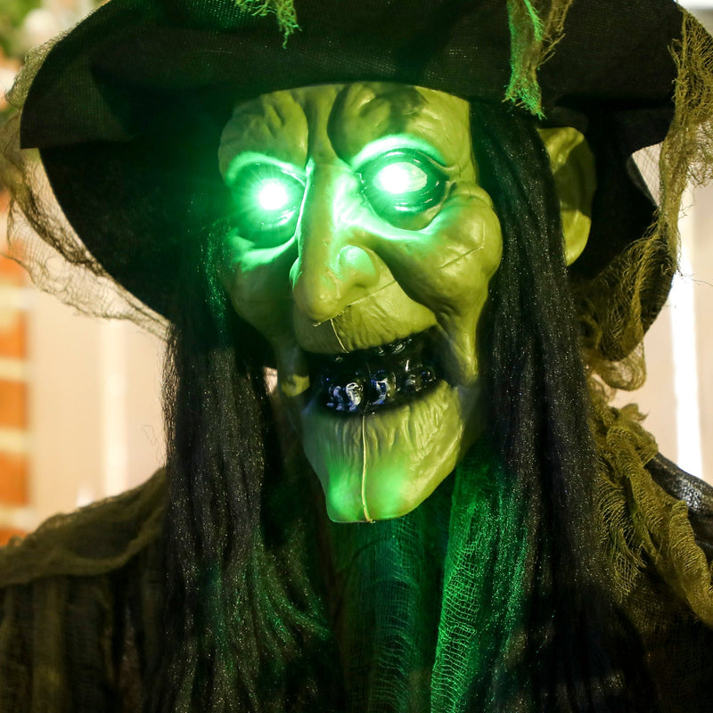 Close-up of the Outsunny Halloween witch's face with glowing green light-up eyes