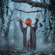 Hanging zombie decoration displayed among trees with crows in a foggy forest scene