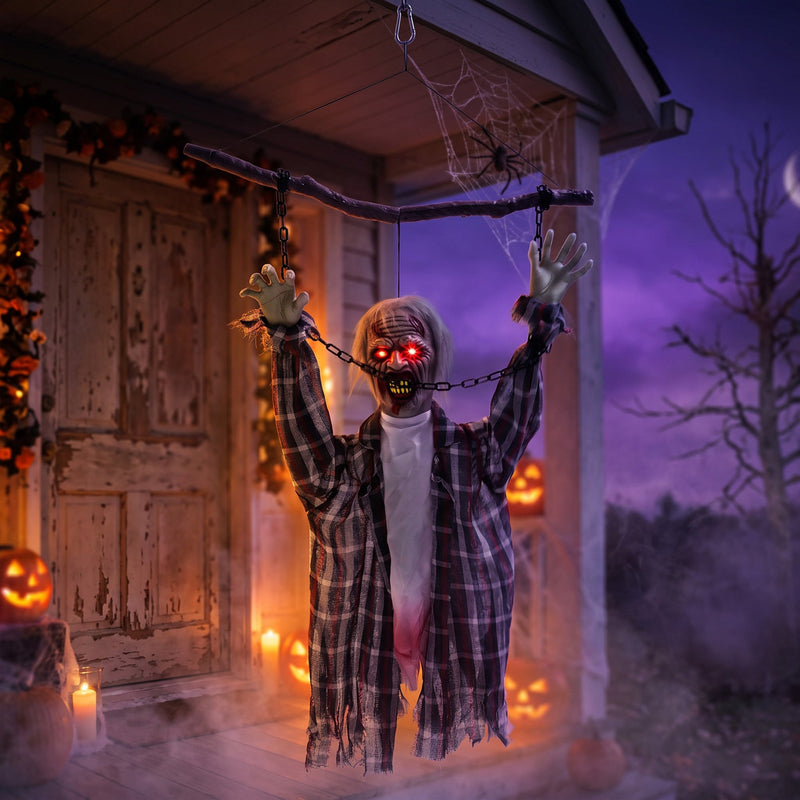 Hanging zombie decoration displayed on a porch entrance at night
