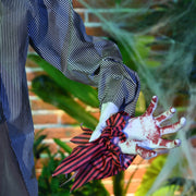 Close-up of the severed hand held in the zombie's striped sleeve