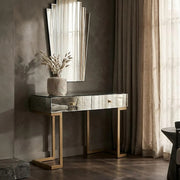 Mirrored console table dressed with a lamp and tray in a living room setting