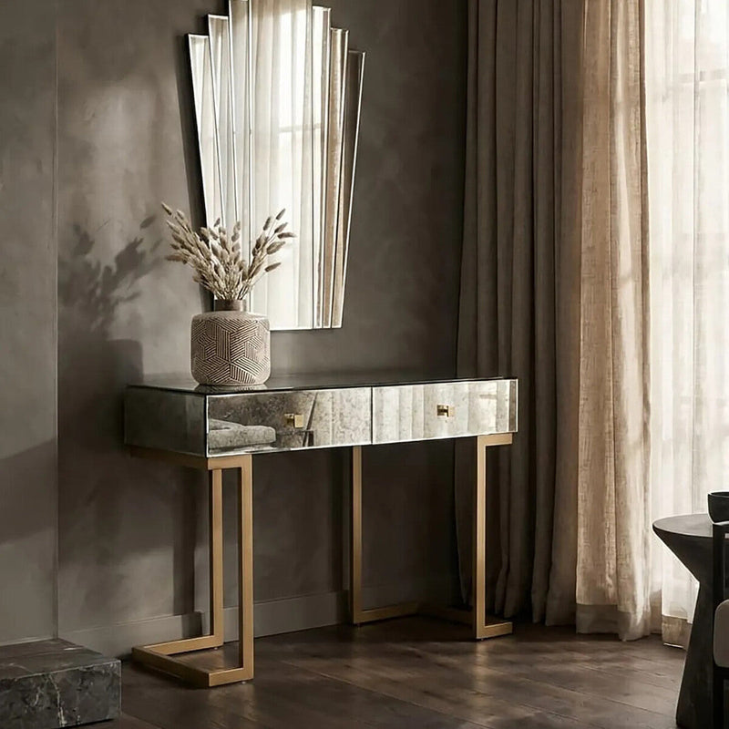 Mirrored console table dressed with a lamp and tray in a living room setting