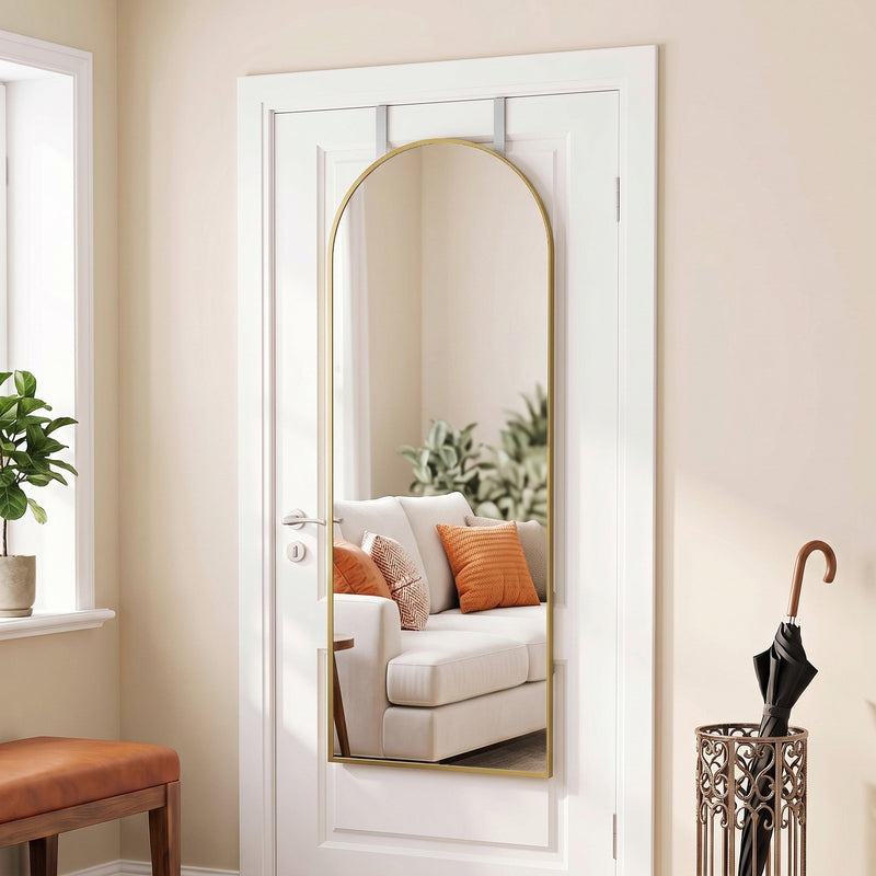 Arched over-door mirror reflecting a sofa, next to an umbrella stand