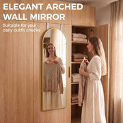 Woman choosing an outfit in front of an arched mirror next to an open wardrobe